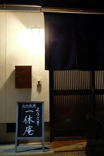 a sign in front of a door with writing on it at 1日1組限定 5LDKお洒落古民家 駐車場2台 夜景を望む宿 "一休庵" Traditional house with yard and parking in Hiroshima