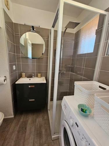 une salle de bain avec un lavabo et une machine à laver dans l'établissement Studio vue mer panoramique, accès plage, piscine, à Sainte-Maxime