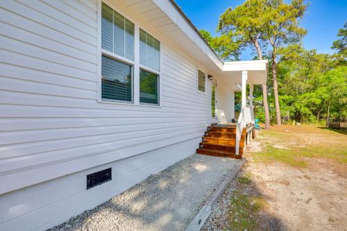 a house with a porch with a bench on the side at Modern Oak Island Escape 1 Mile to Long Beach! in Oak Island