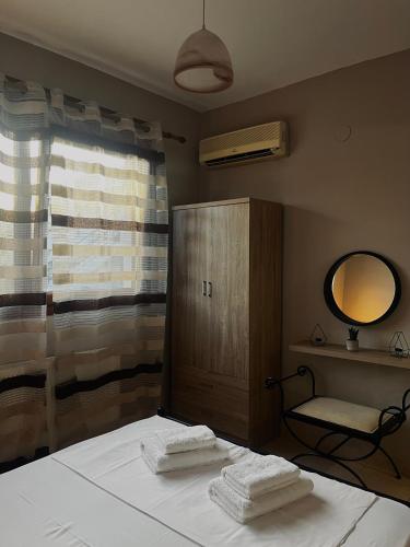 a bedroom with a bed with two towels on it at Elena House in Nea Peramos
