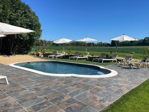 - une piscine sur une terrasse avec des chaises et des parasols dans l'établissement Écrin de la baie, à Pouldergat