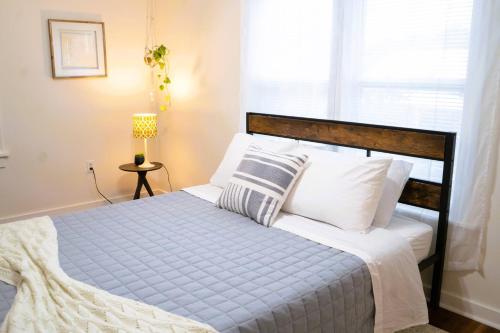 a bedroom with a bed with a wooden headboard and pillows at Summer House - 1Br-1Ba - Second Floor Apt - Five Minute Walk To City Gates in St. Augustine