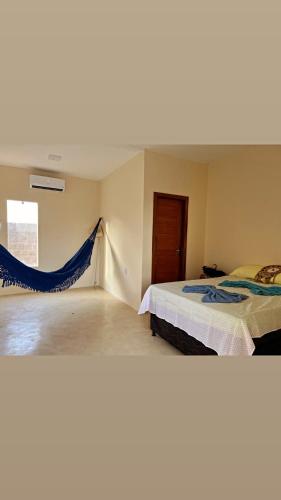 a bedroom with two beds and a hammock between them at Madeiros Hostel in Tibau do Sul