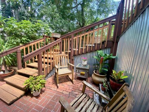 a patio with two wooden benches and potted plants at Summer House - 1Br-1Ba - Second Floor Apt - Five Minute Walk To City Gates in St. Augustine