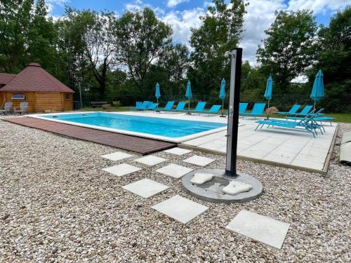 une piscine avec des chaises bleues et des parasols dans l'établissement Mobil-home 3 chambres 6 personnes au camping de bairon 08390, à Le Chesne