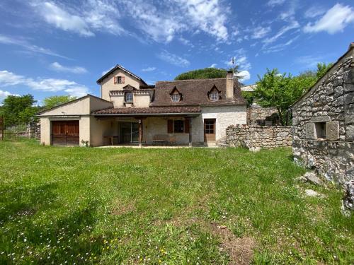 an old stone house with a grass yard at La Bergerie d'Olivier in Saint-Cirq-Lapopie