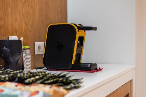 a black and yellow appliance sitting on a counter at Marina Luxury Suites by PS in Durrës