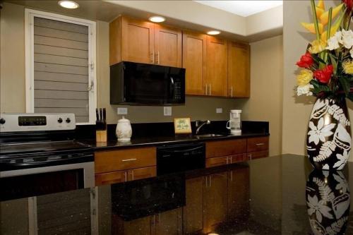 una cocina con armarios de madera y un jarrón de flores en Maui Kaanapali Villas 408 condo, en Lahaina