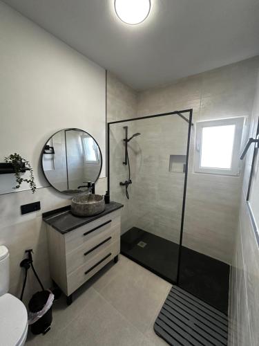 マタラスカニャスにあるMarismas al marのシャワー、洗面台、鏡を備えたバスルーム