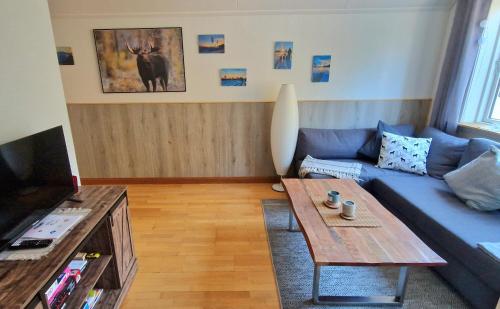 a living room with a blue couch and a coffee table at Stationshuset Dalarna Apartments in Sörsjön