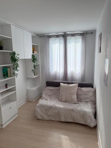 - une chambre blanche avec un lit et des oreillers dans l'établissement Beautiful and modern apartment close to Paris, à Villeneuve-la-Garenne