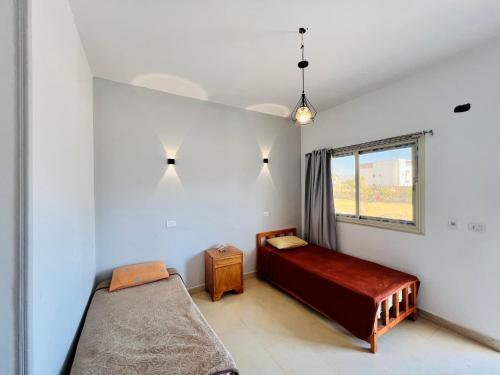 a bedroom with a bed and a window at Boutique sea lodge in Nuweiba‘ el Muzeinah