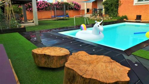 une piscine avec un lapin en peluche et des bûches dans une cour dans l'établissement Villa moderne avec toutes les commodités, proche de la mer, à Bernis