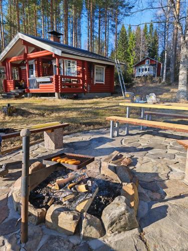 a log cabin with a fire pit in front of it at Villa Lahtela in Kajaani