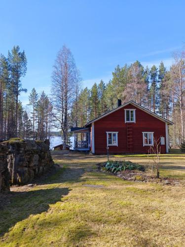 a red house in the middle of a field at Villa Lahtela in Kajaani