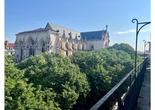 un vieux bâtiment avec des arbres devant lui dans l'établissement Confort et raffinement au cœur du 6ème, à Lyon
