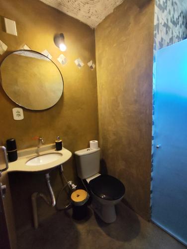 un bagno con un water, un lavandino e uno specchio di Flor do Cajueiro a Lençóis