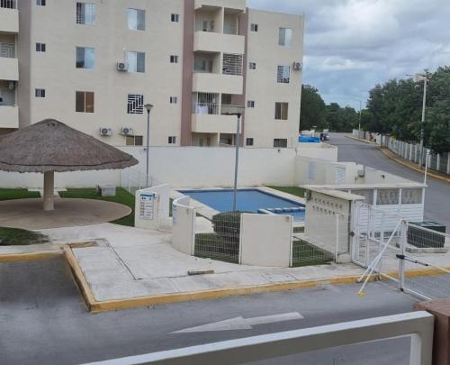 a swimming pool in front of a building at Apartmento nuevo con alberca, Cancun in Cancún