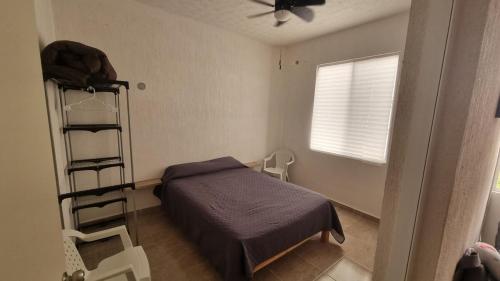 a bedroom with a bed and a ladder and a window at Apartmento nuevo con alberca, Cancun in Cancún