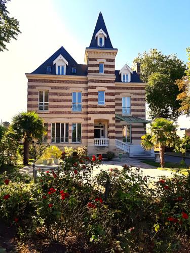 une grande maison avec une tour en haut dans l'établissement 200m de la mer Piscine WIFI T2 41m2 4 pers 1 chambre refait à neuf hypercentre, à Cabourg