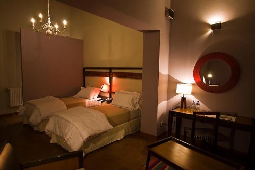 a bedroom with two beds and a table and a mirror at Hotel Huacalera in Huacalera