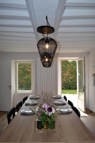 une salle à manger avec une grande table et un lustre dans l'établissement Happy Home Saint-Lô, à Saint Lo