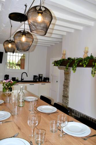 une table avec des assiettes et des verres au-dessus dans l'établissement Happy Home Saint-Lô, à Saint Lo