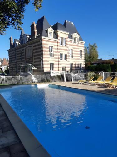 une grande maison avec une piscine devant dans l'établissement 200m de la mer Piscine WIFI T2 41m2 4 pers 1 chambre refait à neuf hypercentre, à Cabourg