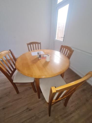 a wooden table and chairs in a room at The Oaks in Grays Thurrock
