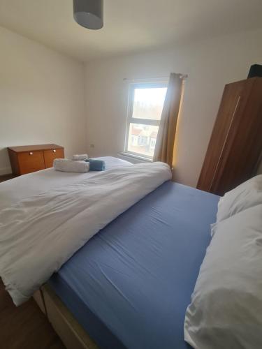 a large bed in a bedroom with a window at The Oaks in Grays Thurrock