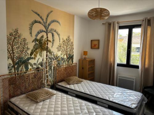 - une chambre avec un lit et une fresque murale en palmier dans l'établissement Gîte de Montfort, à Caromb