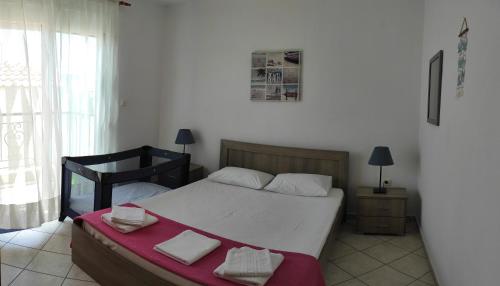a bedroom with a bed and a table with towels at Roses RT apartments Skioni I in Nea Skioni