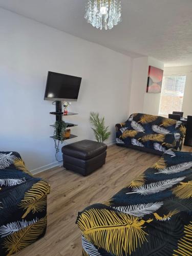 a living room with two couches and a flat screen tv at A City Centre family house in Peterborough