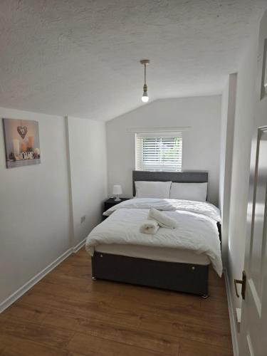 a bedroom with a bed in a white room at A City Centre family house in Peterborough