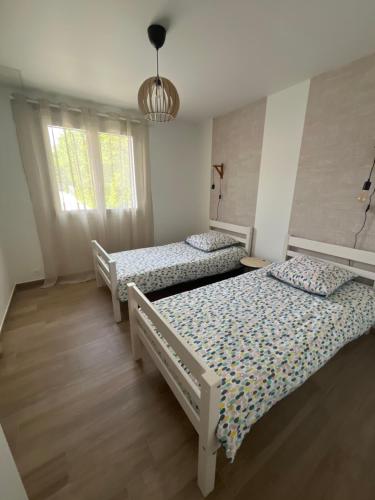 une chambre avec deux lits et une fenêtre dans l'établissement Maison à la campagne, à Baguer-Pican
