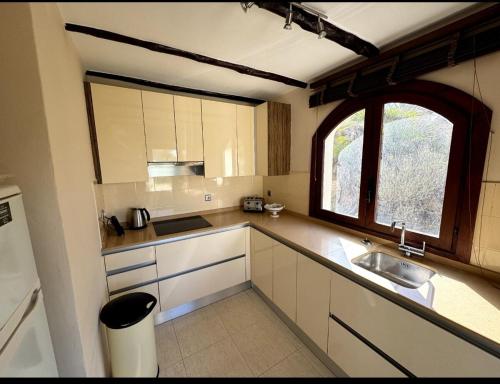 a small kitchen with a sink and a window at Casa de Ensueño - exklusive Villa mit 3 Schlafzimmern, 3 Bädern, 4 Terrassen mit Panoramaausblick in Atamaría