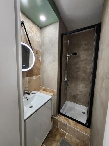 La salle de bains est pourvue d'une douche et d'un lavabo blanc. dans l'établissement Le Roof Top du Port, Nouveau, Bbq Duplex Clim Parking, à Gruissan