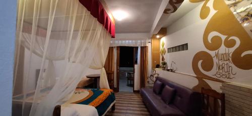 a bedroom with a bed and a couch in a room at Umah de Madya The Room & Panoramic Rooftop Munduk in Munduk