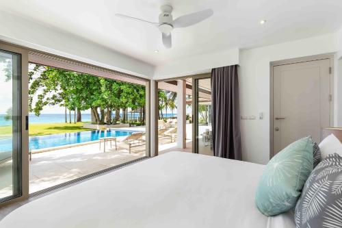 a bedroom with a bed and a view of a pool at Villa Sand in Pilai Beach