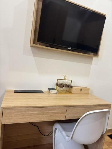 a desk with a television and a white chair at Oak Haven Sydney Suites in Sydney