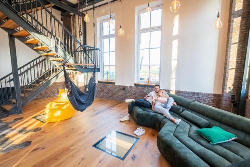 two people sitting on a couch in a loft at Loft Pumpensaal im historischen Wasserwerk Tecklenburg 150qm Außergewönliches Erlebnis in Tecklenburg
