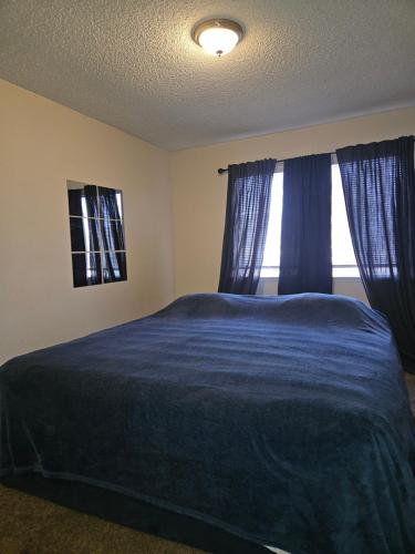 Un dormitorio con una cama azul y una ventana. en Cozy Quiet Quarters!, en Las Vegas