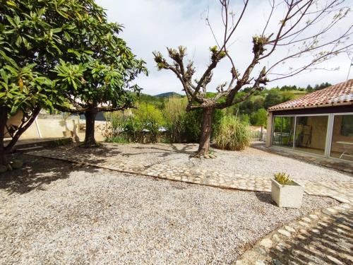 a garden with trees and a house at Le Cabrials in Le Poujol-sur-Orb