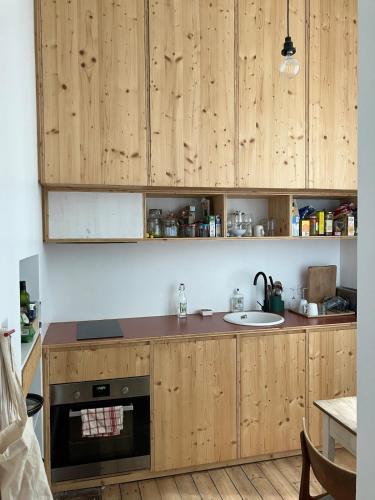 une cuisine avec des armoires en bois et un évier dans l'établissement Appartement d'architecte, à Saint-Brieuc