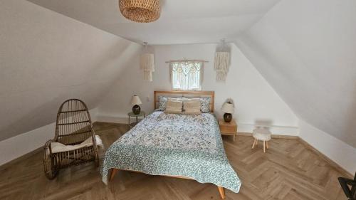 a bedroom with a bed and a chair at Dom letniskowy do wynajęcia z własną Przystanią nad rzeką Narew - linia brzegowa in Dzbenin