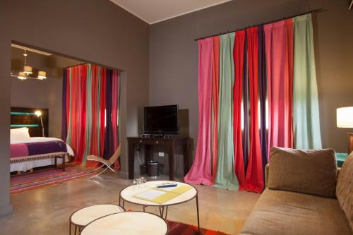 a living room with red curtains and a bed at Hotel Huacalera in Huacalera