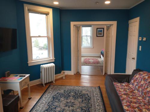 a blue living room with a couch and a window at Comfortable 3 Bedroom Apartment 30 Minutes to New York in Pfister Helistop