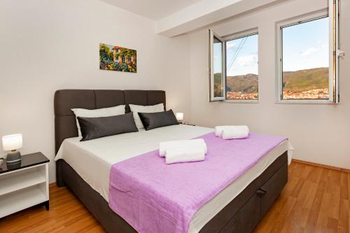 a bedroom with a large bed with a purple blanket at Boris & Matej Apartments in Ohrid