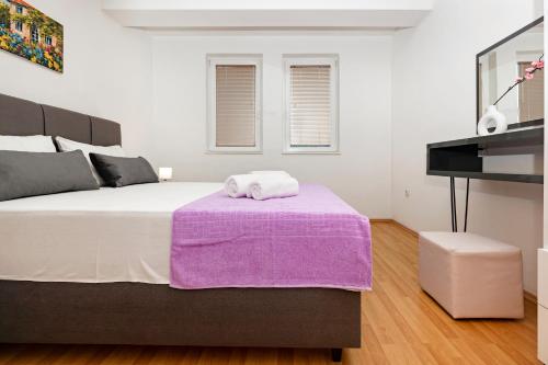 a bedroom with a large bed with a purple blanket at Boris & Matej Apartments in Ohrid