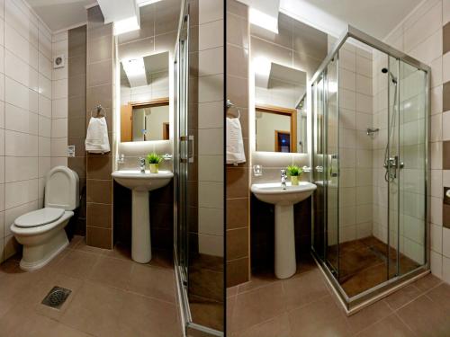 a bathroom with two sinks and a shower and a toilet at Boris & Matej Apartments in Ohrid